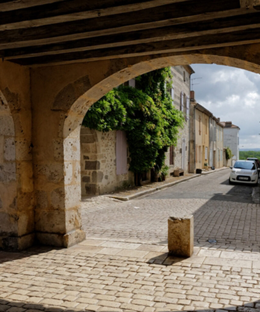 Photographie d'une rue et d'une arche à Damazan